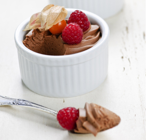 Two chocolate mousse desserts with a spoon